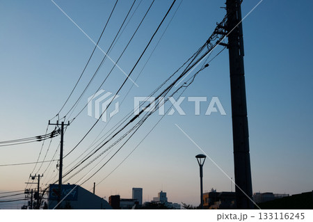 夕暮れに映える電信柱と電線のシルエット 夕暮れに映える電信柱と電線のシルエット 133116245
