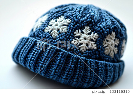 Minimalist Craft. Winter knitted hat with a snowflakes pattern on a winter background. Christmas atmosphere. Creative hobby. Minimalist Craft. Winter knitted hat with a snowflakes pattern on a winter background. Christmas atmosphere. Creative hobby. 133116310