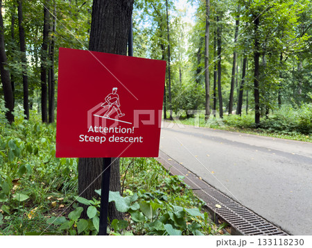 Attention Steep descent. Bight warning sign with descent symbol and inscription is posted. Passerby safety in the indoor park. Beware of elevation changes on street. Safety sign for walking people Attention Steep descent. Bight warning sign with descent symbol and inscription is posted. Passerby safety in the indoor park. Beware of elevation changes on street. Safety sign for walking people 133118230