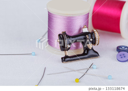 still life of a skein of thread for sewing, needles, buttons, sewing machine on a white background still life of a skein of thread for sewing, needles, buttons, sewing machine on a white background 133118674