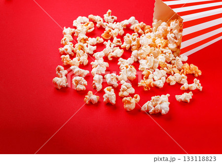 cardboard box with popcorn on a red background cardboard box with popcorn on a red background 133118823