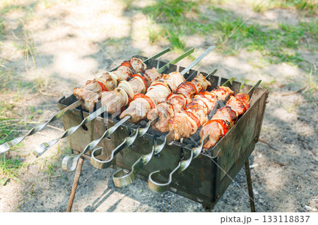 Cooking barbecue with vegetables on skewers. Roasted meat on the grill 133118837