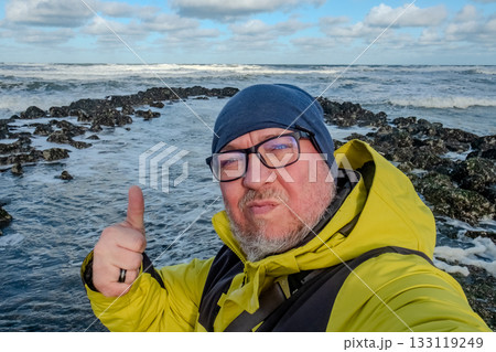 Energetic individual capturing moment on rocky shoreline Energetic individual capturing moment on rocky shoreline 133119249