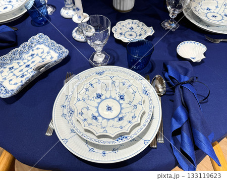 Blue tablecloth with elegant festive dinner setting 133119623