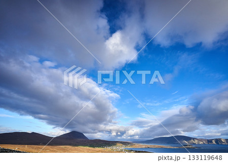 View over the ocean in cloudy blue sky weather with Achill island, Keel vilage and beach 133119648
