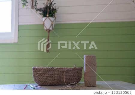 Cozy room with green accents and craft supplies on wooden table 133120565