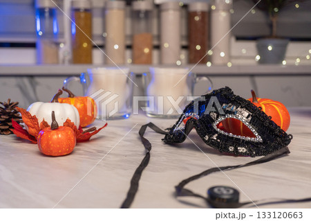 Festive halloween kitchen scene with pumpkins and masquerade mask Festive halloween kitchen scene with pumpkins and masquerade mask 133120663