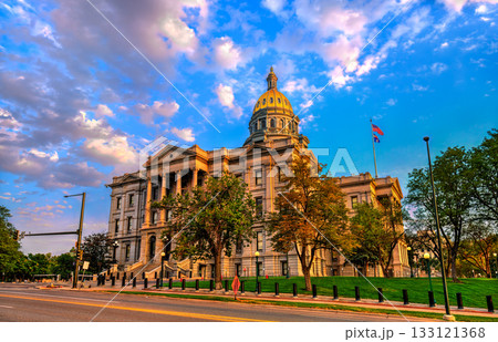 Colorado State Capitol building in Denver lit by golden hour sunset. The gold dome shines under a dramatic blue and pink cloudy sky 133121368