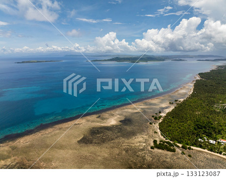 Aerial view of coastline with coral reef and clear blue water under blue sky. Siargao, Philippines. Aerial view of coastline with coral reef and clear blue water under blue sky. Siargao, Philippines. 133123087