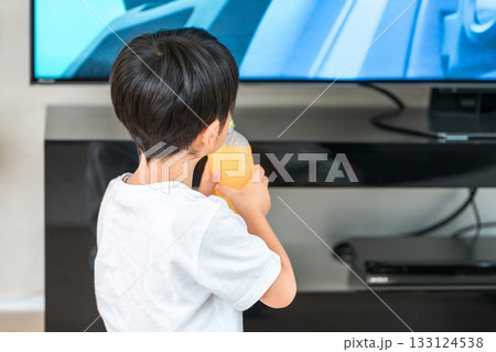リビングでジュースを飲みながらテレビを見る男の子の後ろ姿 リビングでジュースを飲みながらテレビを見る男の子の後ろ姿 133124538