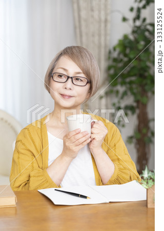 リビングでエンディングノートを書くシニア女性 133125524