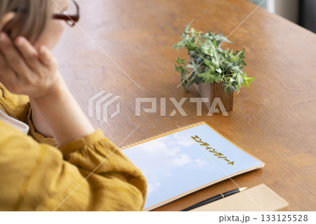 リビングでエンディングノートを書くシニア女性 133125528