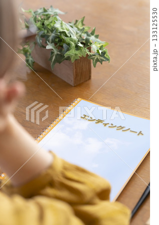 リビングでエンディングノートを書くシニア女性 リビングでエンディングノートを書くシニア女性 133125530