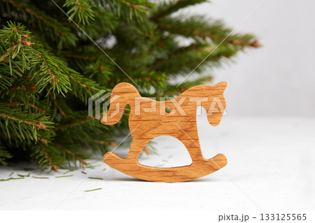 A decorative wooden rocking horse near the Christmas tree. A symbol of the New Year 2026 133125565