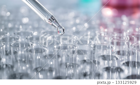 試験管に液体を滴下するスポイトのクローズアップ｜製薬・研究開発のイメージ 133125929