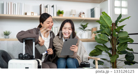 Mother and Daughter Exploring Travel Plans. A mother and daughter looking at a tablet while planning their journey. Mother and Daughter Exploring Travel Plans. A mother and daughter looking at a tablet while planning their journey. 133126125