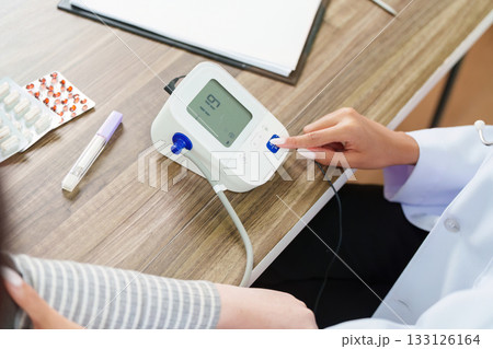 Blood Pressure Monitoring. Doctor using a device to check patient's blood pressure. Blood Pressure Monitoring. Doctor using a device to check patient's blood pressure. 133126164