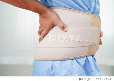 Asian senior wearing elastic support belt can help reduce back pain. Asian senior wearing elastic support belt can help reduce back pain. 133127603