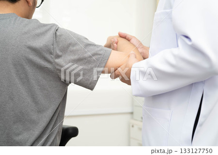 Physical therapy, Asian therapist doctor treat perform pain young man in hospital. Physical therapy, Asian therapist doctor treat perform pain young man in hospital. 133127750