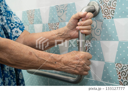 Asian elderly woman use safety handrail in bathroom. 133127777