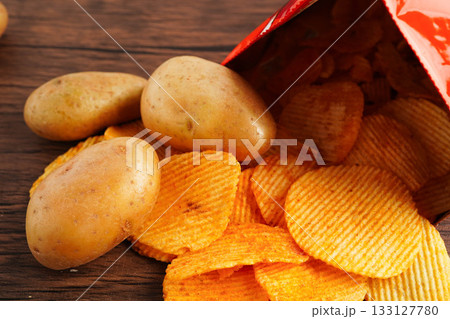 Potato chips in open bag, delicious BBQ seasoning spicy for crips, thin slice deep fried snack fast food. Potato chips in open bag, delicious BBQ seasoning spicy for crips, thin slice deep fried snack fast food. 133127780