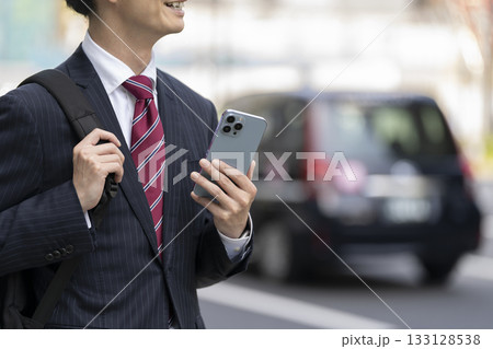 スマートフォンを持ったビジネスマンの手元 スマートフォンを持ったビジネスマンの手元 133128538