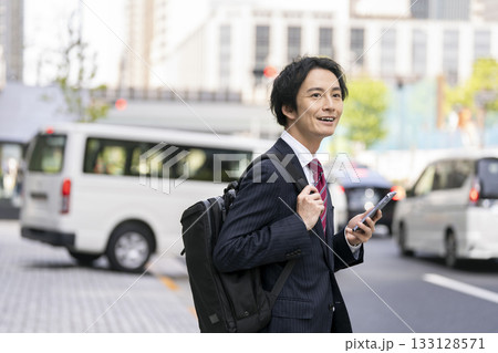 街角に立つスマートフォンを持ったビジネスマン 133128571