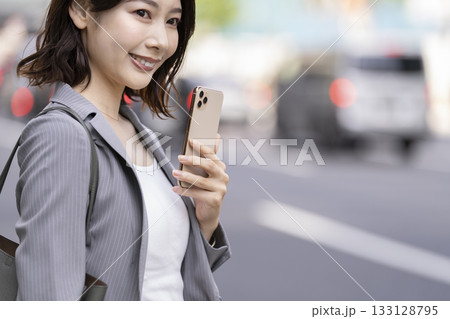スマートフォンを持ったビジネスウーマンの手元 133128795