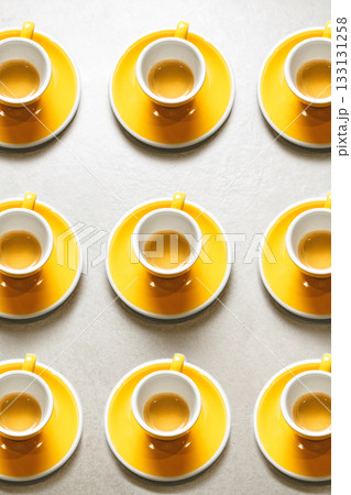Several Espresso Cups in Vibrant Yellow Design Filled With Coffee Arranged on Flat Surface, Top View 133131258