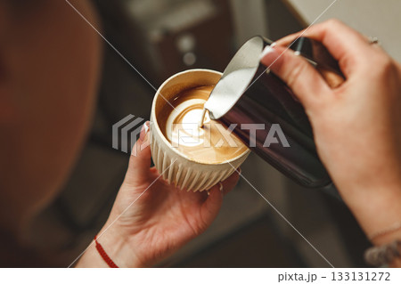 Professional Barista Hand Creating Latte Art While Preparing Cappuccino in Coffee Shop During Morning Rush Professional Barista Hand Creating Latte Art While Preparing Cappuccino in Coffee Shop During Morning Rush 133131272