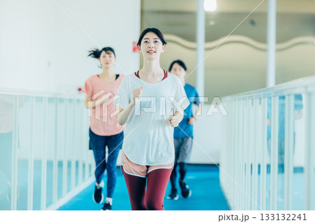 ランニングを室内トラックでする男女 ランニングを室内トラックでする男女 133132241