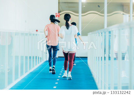 ランニングを室内トラックでする男女 ランニングを室内トラックでする男女 133132242