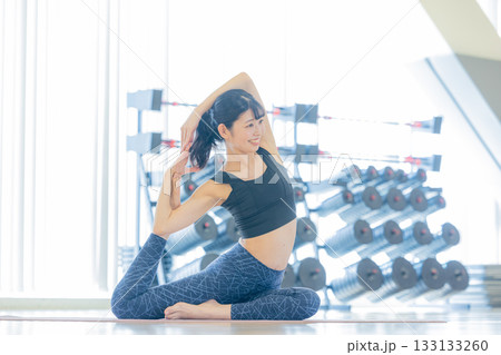 トレーニングジムでストレッチをする若い女性 トレーニングジムでストレッチをする若い女性 133133260
