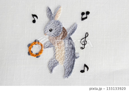 タンバリンを持って踊るグレーのウサギの刺繍 133133920