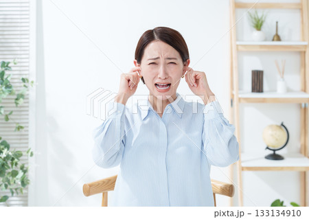 騒音から耳を塞ぐ女性 133134910