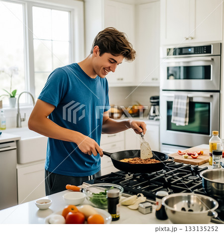 Young man cooking pasta in a bright kitchen while smiling and enjoying the process 133135252