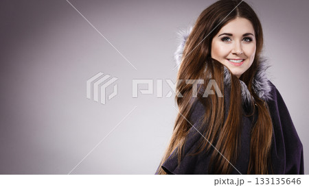 Happy woman wearing dark poncho with hood 133135646