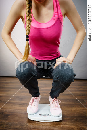 Teenage woman on bathroom scale machine 133135710