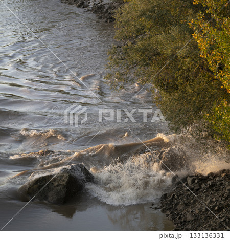Strong waves crash on rocks along the Vague mascaret in Podensac, Gironde 133136331