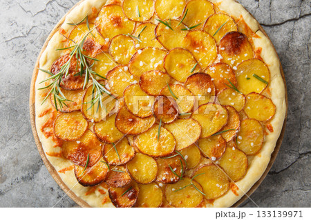 Mozzarella potato pizza and sprinkle with rosemary, salt, pepper closeup on the wooden board. Horizontal top view Mozzarella potato pizza and sprinkle with rosemary, salt, pepper closeup on the wooden board. Horizontal top view 133139971