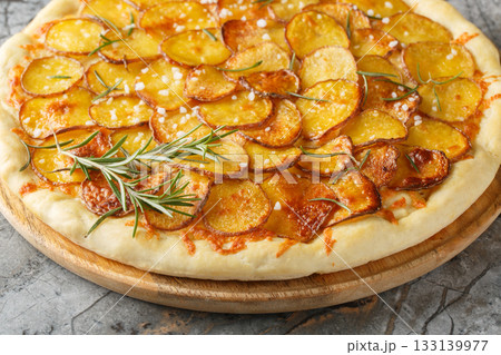Mozzarella potato pizza and sprinkle with rosemary, salt, pepper closeup on the wooden board. Horizontal 133139977