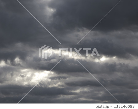 雲の隙間から水平に光が差し込む重厚な雨雲 133140085