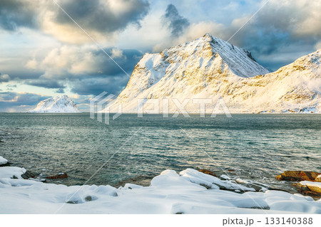 Amazing winter view of Vik and Haukland beaches during sunset with lots of snow  and snowy  mountain peaks near Leknes 133140388