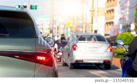 Rear side of dark green car with turn on brake light. Many car prepar for start to go from green light signal. Blurred of town at day time. Rear side of dark green car with turn on brake light. Many car prepar for start to go from green light signal. Blurred of town at day time. 133140510