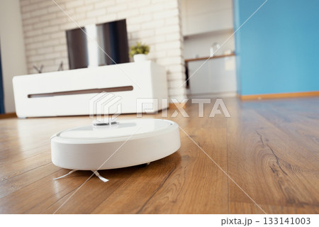 White robot vaccum cleaner in the living room White robot vaccum cleaner in the living room 133141003
