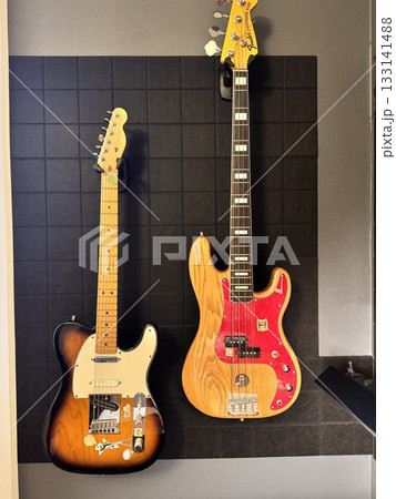 Two acoustic guitars on a black background on the wall. High quality photo Two acoustic guitars on a black background on the wall. High quality photo 133141488