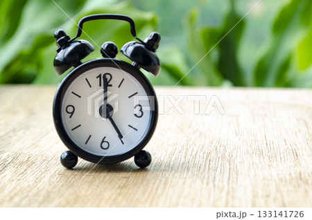 Alarm clock pointing at 5 pm with customizable background space for text or ideas. Alarm clock pointing at 5 pm with customizable background space for text or ideas. 133141726