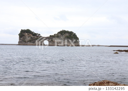 海にぽっかり開く自然の窓 — 岩のアーチが描く静かな海景 133142295