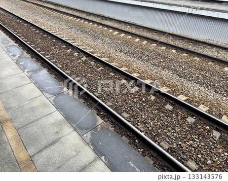 The edge of railway station platform. The high platform poses a risk of falling onto the tracks and causing injury. Background for project on safe walking at a railway station 133143576