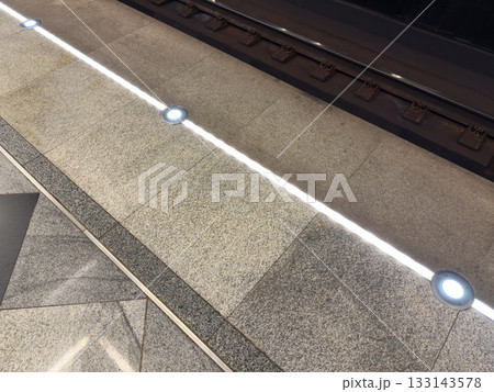 Lighted line in the subway to prevent accidents. Stand behind the line when a train arrives to ensure safety. Warning line at the edge of the platform is illuminated for visibility Lighted line in the subway to prevent accidents. Stand behind the line when a train arrives to ensure safety. Warning line at the edge of the platform is illuminated for visibility 133143578